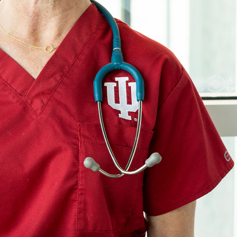 A closeup of a nursing uniform with a trident and stethoscope