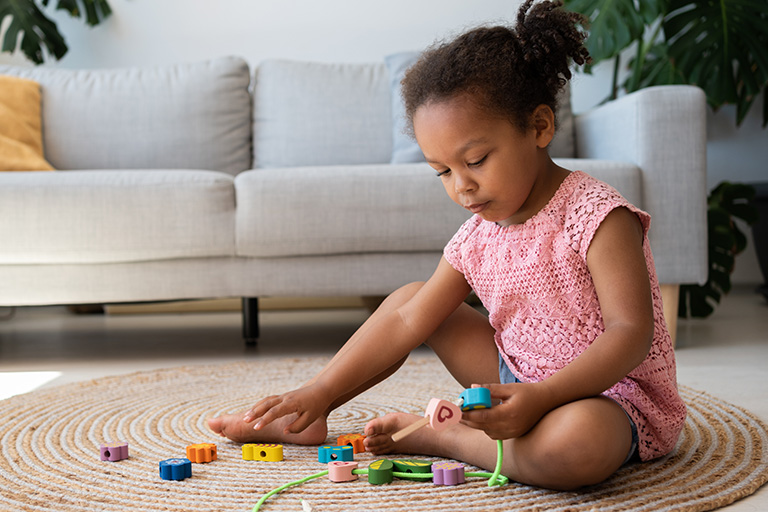 A toddler playing with a toy on top of a rug