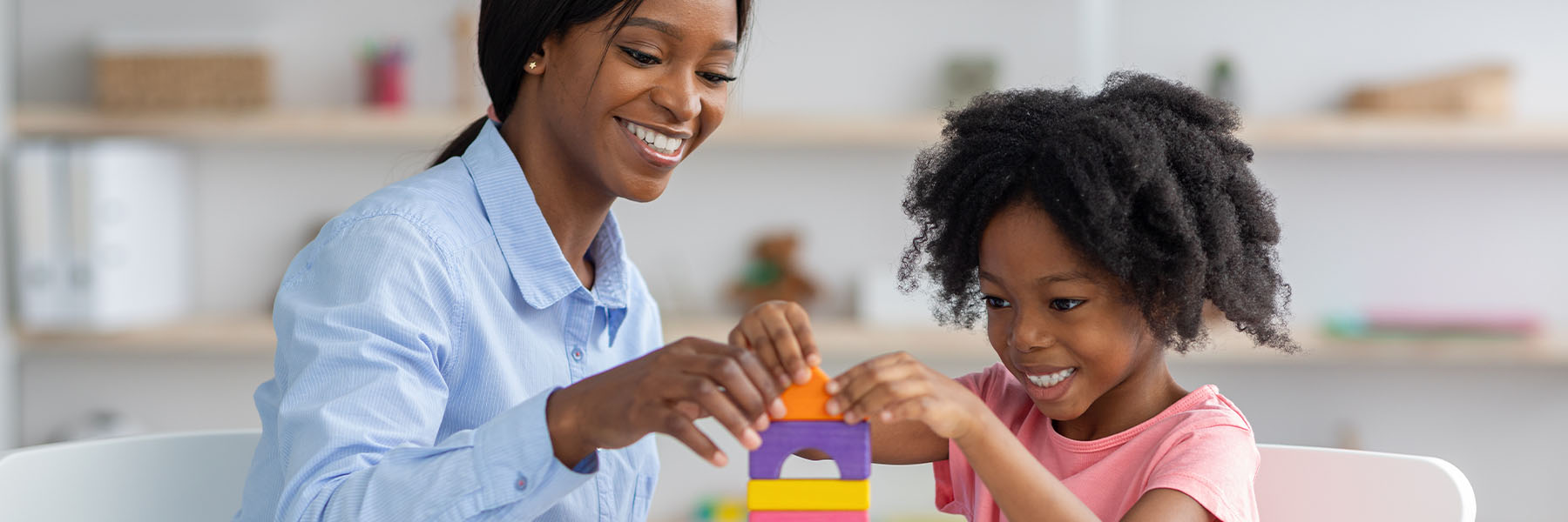 A teacher playing blocks with her student