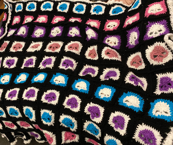 A picture of a crocheted skull blanket.