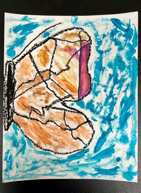 A child's painting of a half butterfly with tan and pink colored wings on a blue background.